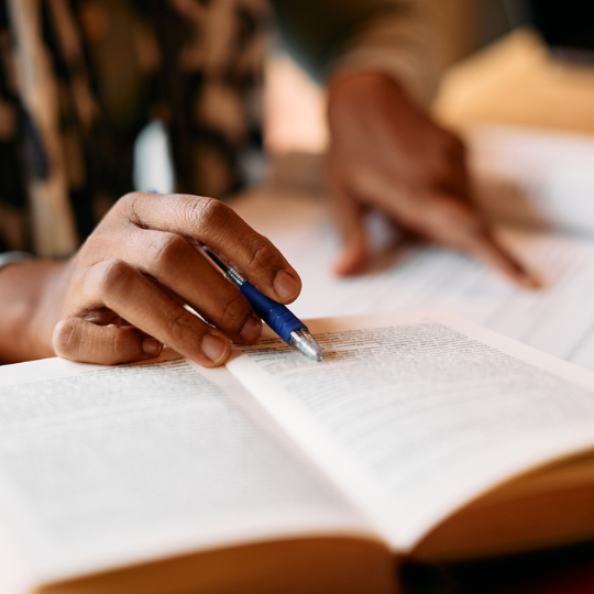 Close up of hands over a text book